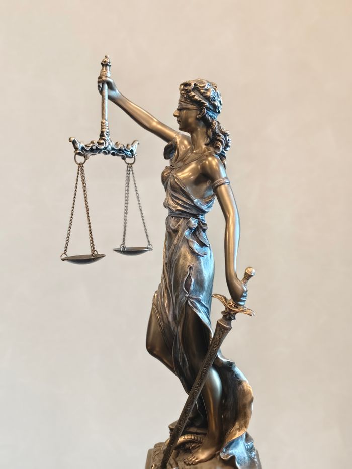 Services Bronze statue of Lady Justice balancing scales and holding a sword, symbolizing law and order.
