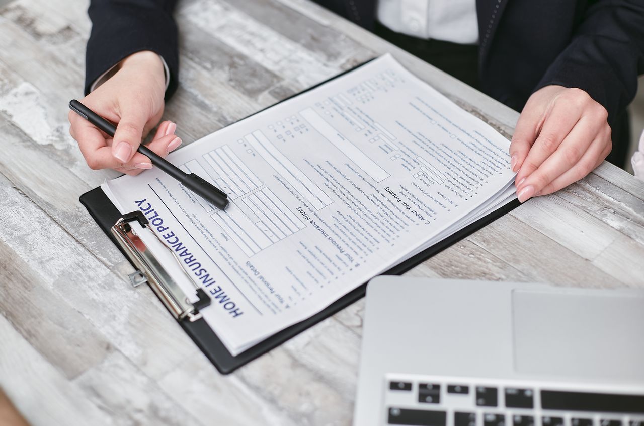 Services Close-up of hands reviewing a home insurance policy, emphasizing professionalism and finance.