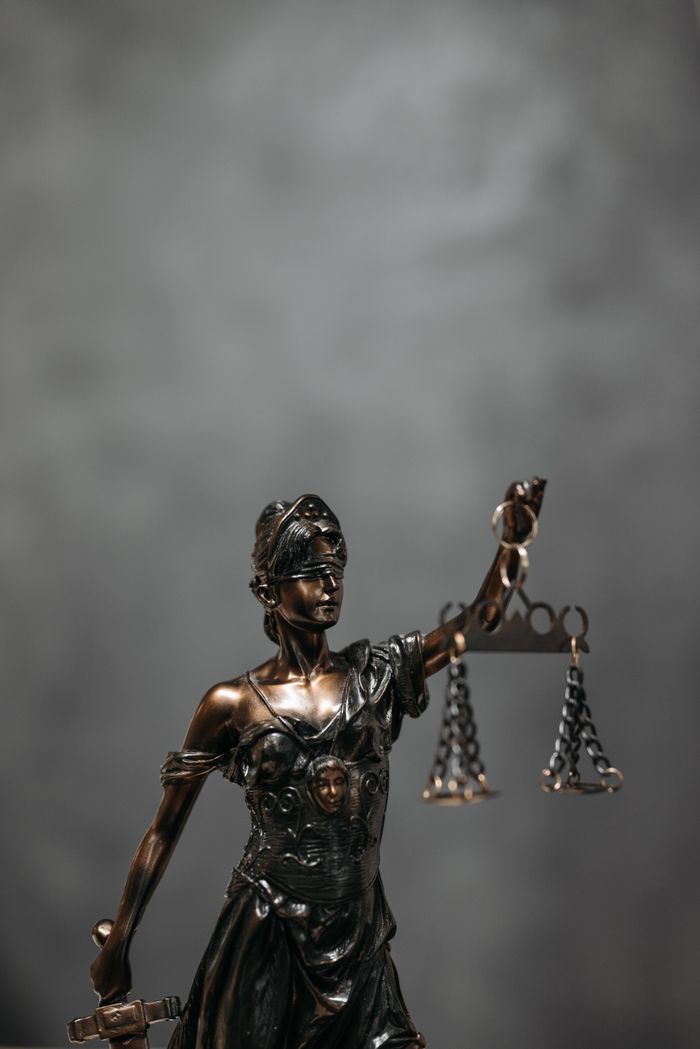 The Art of Drawing Readers In: Your attractive post title goes here Close-up of a bronze Lady Justice statue holding scales, symbolizing law and fairness.